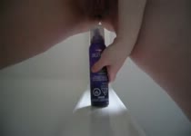 Voor de webcam laat het meisje de spuitbus helemaal haar vagina in glijden