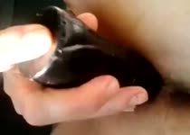 Soepel glijd de zwarte dildo diep haar kale kut in